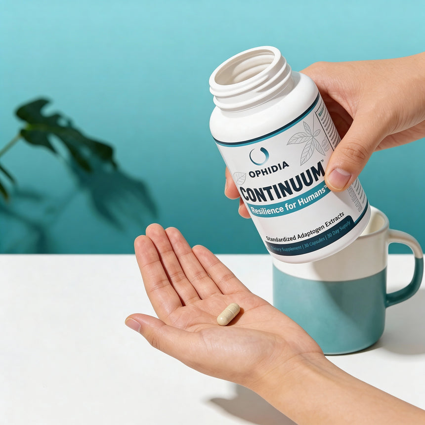 Hand holding a Continuum capsule while another hand tips an Ophidia Continuum bottle above a mug.